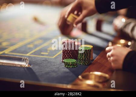 Mani di persone al tavolo della roulette. Foto Stock