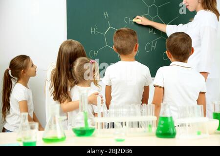 Cute alunni con insegnante che fa ricerca biochimica in classe chimica Foto Stock