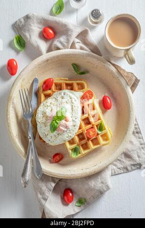 Vista superiore sui waffle con uova fritte e pomodori ciliegini Foto Stock