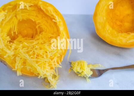 Uno spaghetti cotto, dimezzato, separato in trefoli con una forchetta. Foto Stock