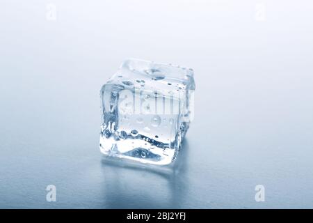 Concetto di perfezione - cubo di ghiaccio su sfondo grigio Foto Stock