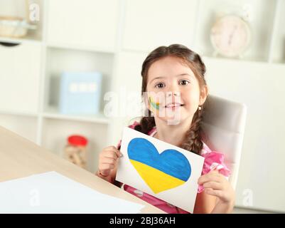 Ragazza piccola cute con immagine sullo sfondo interno domestico Foto Stock