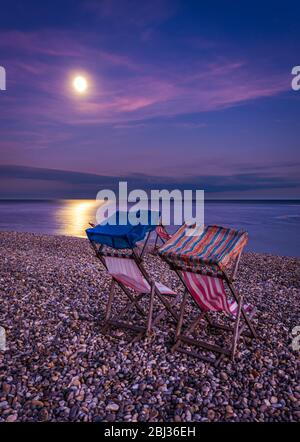 Sedie a sdraio sulla spiaggia al chiaro di luna. Foto Stock
