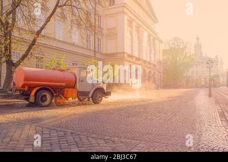 Foto panoramica di prima mattina con lavaggio auto della strada con acqua in Piazza Rynok vicino al Municipio a Lviv, Ucraina. Luce solare brillante sul backstage, selec Foto Stock