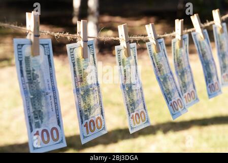 Concetto di riciclaggio di denaro - cento bollette appese su un cavo, all'aperto Foto Stock