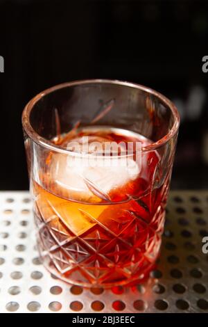 Whisky con una palla di ghiaccio in un bicchiere. Pronto a mangiare. Foto Stock