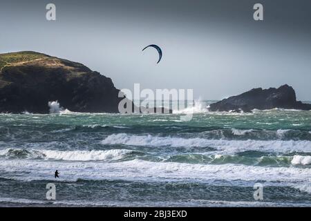 Un solista kite boarder che affronta le condizioni selvagge del vento a Fistral a Newquay in Cornovaglia. Foto Stock