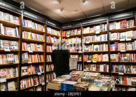 Un cliente che naviga nella sezione della storia di un negozio di libri di Waterstones Book Store a Truro in Cornovaglia. Foto Stock