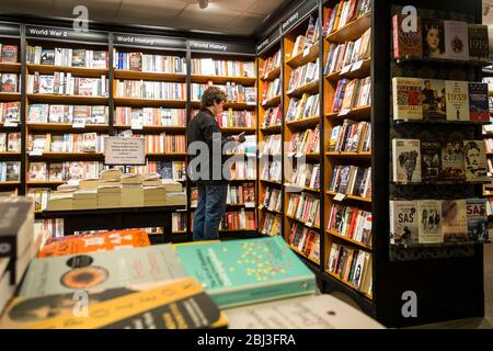 Un cliente che naviga in un negozio di libri Waterstones. Foto Stock