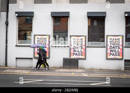 Manchester, Regno Unito. 28 Aprile 2020. La gente cammina davanti a un poster che è stato eretto a causa del COVID-19. L'arte di strada è apparsa in tutta la città dall'inizio della messa in sicurezza del COVID-19. Credit: Andy Barton/Alamy Live News Foto Stock