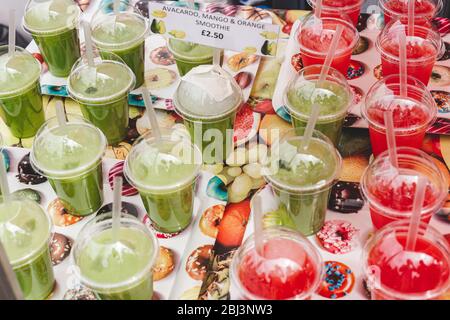 Primo piano di una varietà di frullati in vendita in una stalla in un mercato alimentare. Lo smoothie è una bevanda densa e cremosa a base di frutta cruda purea o di vegetabl Foto Stock