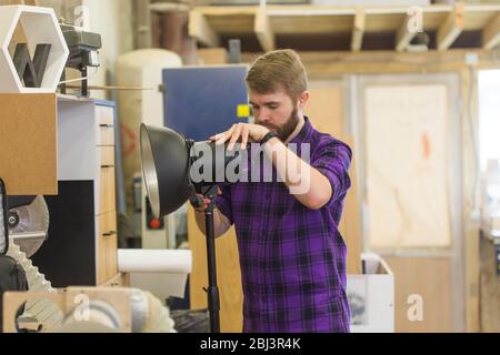 Produzione video e apparecchiature di illuminazione - uomo take away lampada. Foto Stock