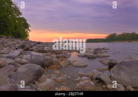 Tramonto su un fiume roccioso tra le foreste del Parco Nazionale di Manas ad Assam in India Foto Stock