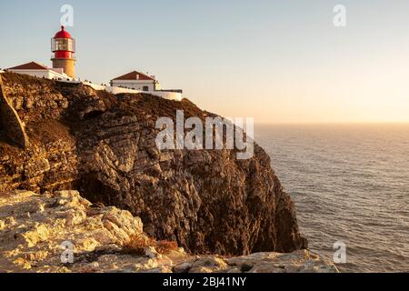 Tramonto a Cliff e faro a Cabo de Sao Vincente. Trekking con Backpacker solo sulla Rota Vicentina e il sentiero dei pescatori in Algarve, Portogallo. WA Foto Stock