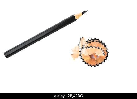 Scaglie di matita di colore marrone posto accanto ad un pastello a matita di legno di colore nero su uno sfondo bianco isolato Foto Stock