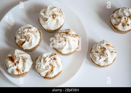 Belle cupcake bianche su un piatto bianco. Foto Stock