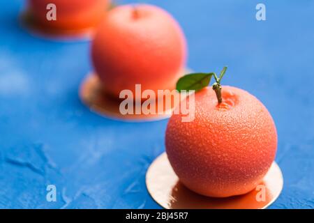 Dolci, torta e concetto delizioso - dessert Mousse a forma di frutta d'arancia. Foto Stock