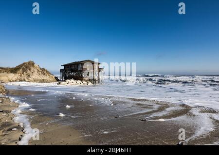 Nags Head Beach house su palafitte circondato da alta marea tempesta surf. Foto Stock