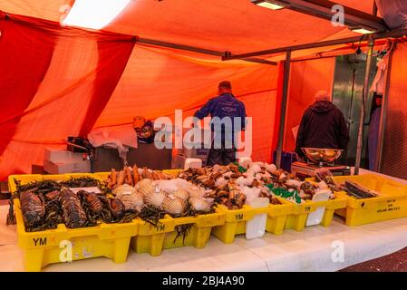 Amsterdam, Paesi Bassi - 8 settembre 2018: Venditore in un negozio di pesce e frutti di mare nel mercato Albert Cuyp, mercato di strada ad Amsterdam, Paesi Bassi Foto Stock