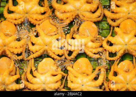 Concetto di Street food. Sfondo di calamari gialli su foglia di banana verde coperta di ghiaccio nel mercato alimentare locale della Thailandia. Il centro dell'immagine è in camera foc Foto Stock