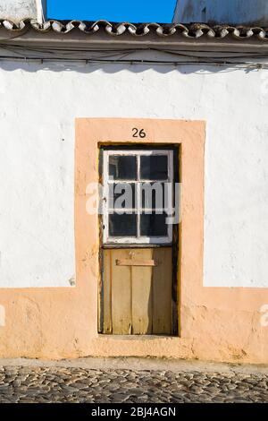 Tipica casa caratteristica con porta d'ingresso vecchia in strada di pietra ciottolata a Evora, Portogallo Foto Stock