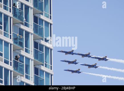 Jersey City, Stati Uniti. 28 Aprile 2020. Gli spettatori guardano dal loro balcone mentre gli US Navy Blue Angels e US Air Force Thunderbirds volano in formazione nel New Jersey dopo aver volato da One World Trade Center e lo skyline di Manhattan a New York City martedì 28 aprile 2020. Una formazione di US Navy Blue Angels e US Air Force Thunderbirds onorano i primi soccorritori sulla prima linea della pandemia di coronavirus volando sopra New York, New Jersey e Pennsylvania. Foto di John Angelillo/UPI Credit: UPI/Alamy Live News Foto Stock