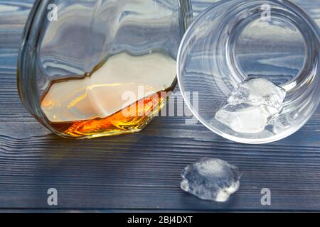 Bicchiere di whiskey su ghiaccio con bottiglia sulla barra di legno Foto Stock