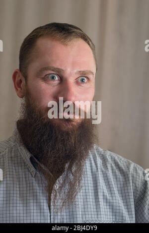 Ritratto di un uomo arrabbiato di colore bianco e grave con barba lunga Foto Stock