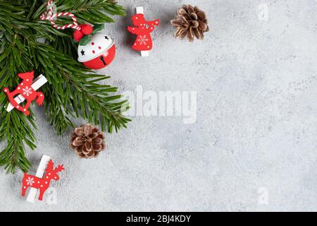 Rami di albero di Natale con decorazioni rosse su un tavolo grigio. Modello per biglietto di auguri o disegno. Banner orizzontale con spazio di copia. Foto Stock