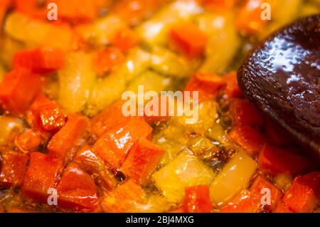 La frittura tritate finemente le carote e le cipolle in olio bollente Foto Stock