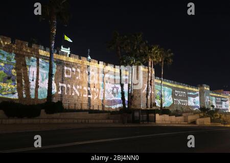 Gerusalemme, Israele. 28 Aprile 2020. Le bandiere israeliane sono proiettate sulle mura della Città Vecchia di Gerusalemme, mentre Israele celebra 72 anni di indipendenza tra la pandemia del coronavirus COVID-19. Il blocco del giorno dell'indipendenza ha effetto come gli israeliani legati alle case. Foto Stock