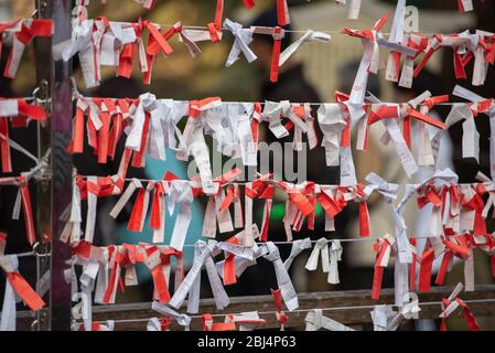 Omikuji, strisce di carta giapponesi che raccontano fortuna e che pendono nel vento al Santuario di Enoshima, Giappone Foto Stock