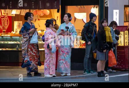 Un gruppo di donne giapponesi vestite con kimono tradizionale in una conversazione alla via principale Shijo-dori di Gion, a Kyoto, Giappone Foto Stock