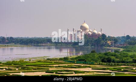 Vista distante del mausoleo Taj Mahal costruito nel 1643 dall'imperatore Mughal Shah Jahan per ospitare la tomba di sua moglie Mumtaz Mahal, accanto alla rivata Yamuna Foto Stock