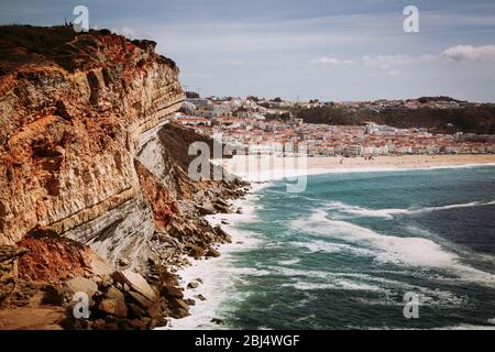 Nazare, Portogallo: Alta scogliera sull'Oceano Atlantico con la città di Nazare sullo sfondo, Portogallo Foto Stock