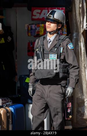 Un poliziotto di pattuglia a piedi al mercato di Ameyoko, Tokyo, Giappone Foto Stock