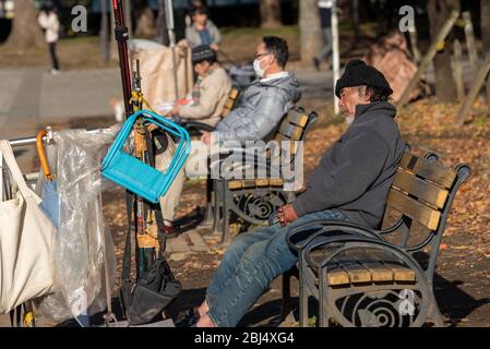 Gli senzatetto dormono su una panchina al parco ueno a Tokyo, Giappone. Foto Stock