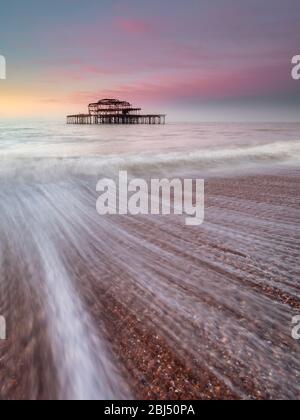 Rosa cielo sopra il vecchio molo Ovest di sunrise. Foto Stock