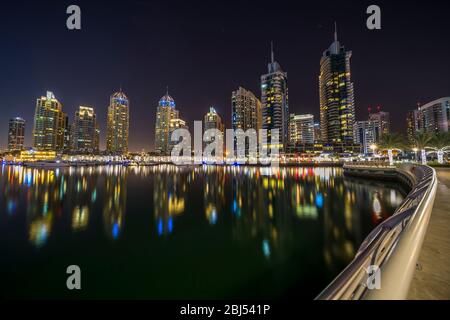 Le acque cristalline della Marina riflettono i ricchi colori dei suoi lussuosi edifici a Dubai. Foto Stock