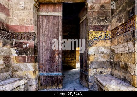 Vecchio ingresso porta di legno alla Moschea di Amir Qurqumas nella Città dei morti del Cairo Foto Stock