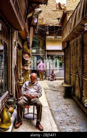 Il venditore si trova fuori dal suo negozio nella zona di Camel Bone del mercato di Khan El Khalili nel Cairo Islamico Foto Stock