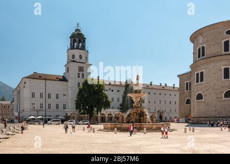 La fontana Residenzbrunnen in estate a Residenzplatz nel centro storico di Salisburgo, Austria, con il museo cittadino sullo sfondo Foto Stock