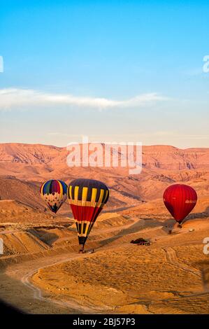 Mongolfiere che atterrano nel deserto intorno alla valle dei re dopo un volo di mattina presto Foto Stock