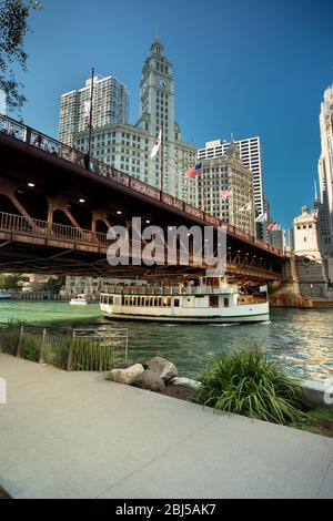 Il traghetto passa sotto il DuSable Bridge sul fiume Chicago nel centro di Chicago, Illinois USA, durante una giornata estiva Foto Stock