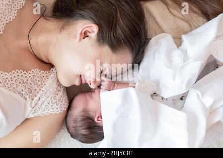 maternità, infanzia, infanzia, famiglia, cura, medicina, sonno, salute, maternità concetto - ritratto di mamma con neonato avvolto in pannolino su Foto Stock