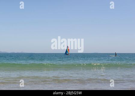 Piccola barca a vela colorata in catamarano nel mare blu. Barca a vela catamarano con vela colorate sul mare. Yachting. Brasile, acque turchesi di Atla Foto Stock