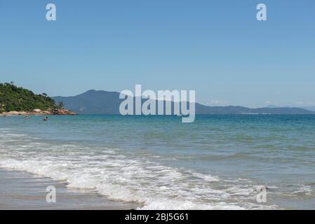 Bella spiaggia nel Brasile meridionale - Città di Florianopolis. Bella vista sul mare verdastro. Giorno di sole nuvoloso - cielo limpido in estate. Foto Stock