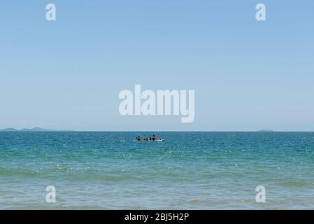 Vista sulla bellissima spiaggia di Florianópolis, Brasile. Due uomini kayak nel mare turchese sotto il cielo limpido bello in vacanza giorno in estate tropicale. Foto Stock