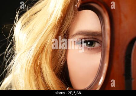 Giovane bella donna con violino su sfondo nero, primo piano Foto Stock