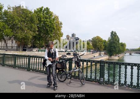 PARIGI - 17 SETTEMBRE 2014: Divertente cane e musicista cantando e suonando la chitarra sul ponte della Senna. Parigi, Francia. Foto Stock